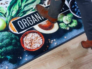 Person kliver på en färgglad entrématta med eget tryck och logotyp designad för företag