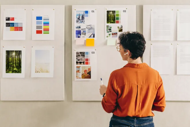 Person som står framför en vägg med moodboards och inspirationsbilder