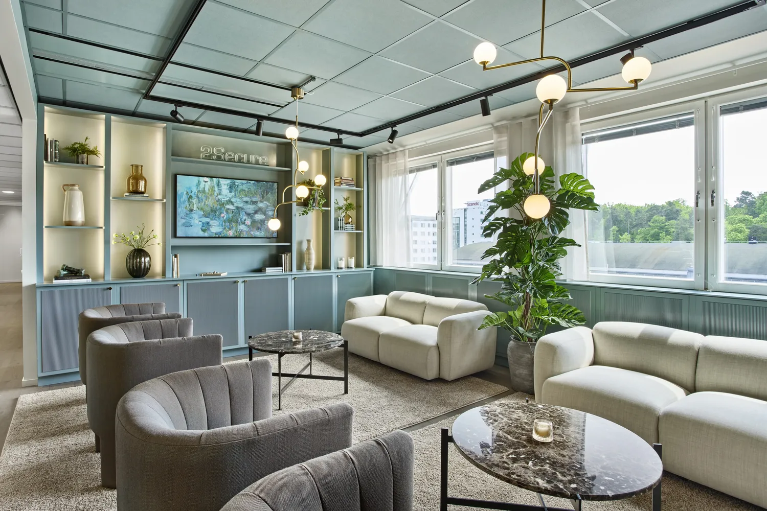 Stilren kontorslounge med moderna soffor, växtinredning och designbelysning för professionell arbetsmiljö