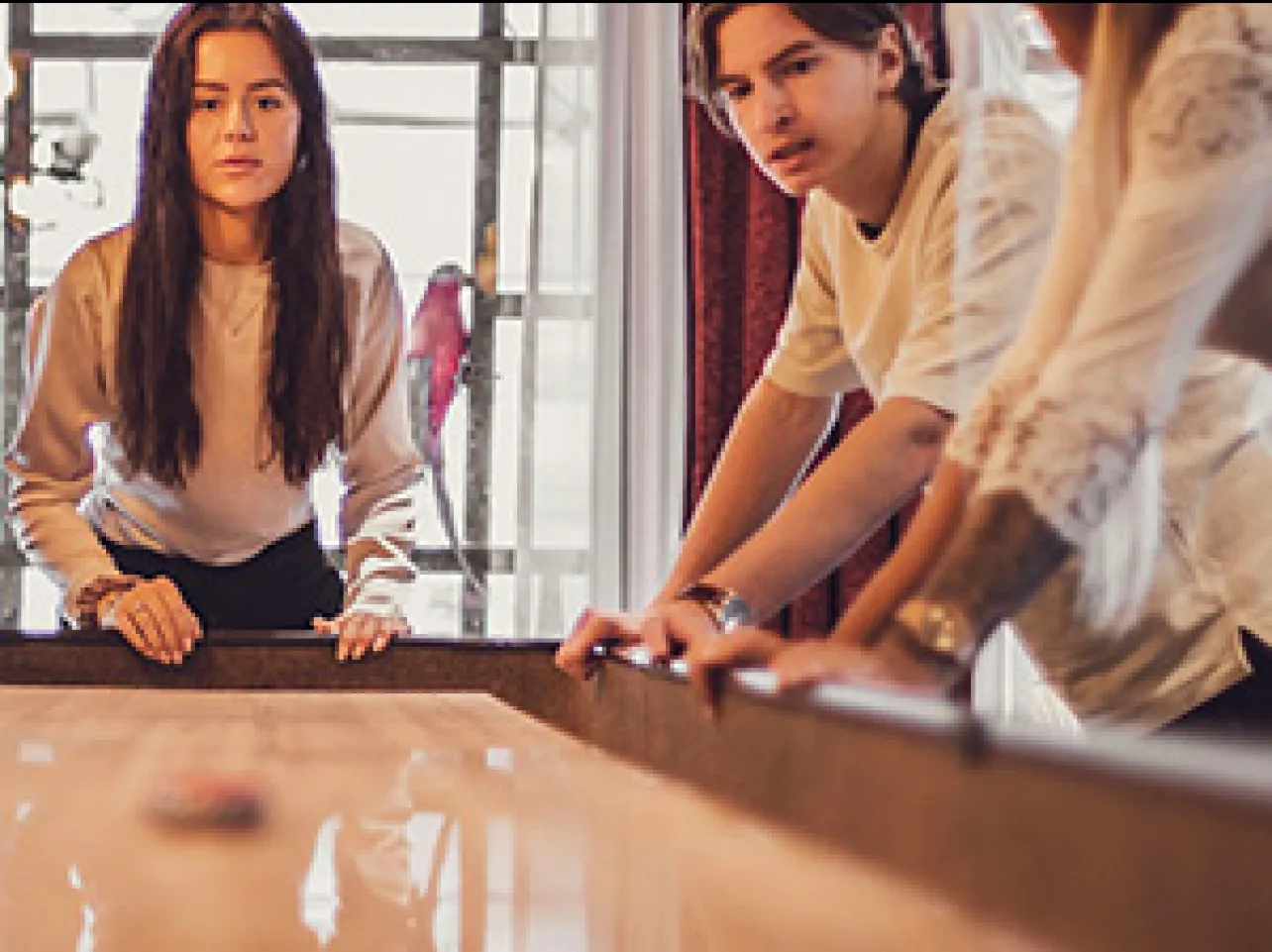 Medarbetare spelar shuffleboard i kontorsmiljö som främjar trivsel och teamkänsla