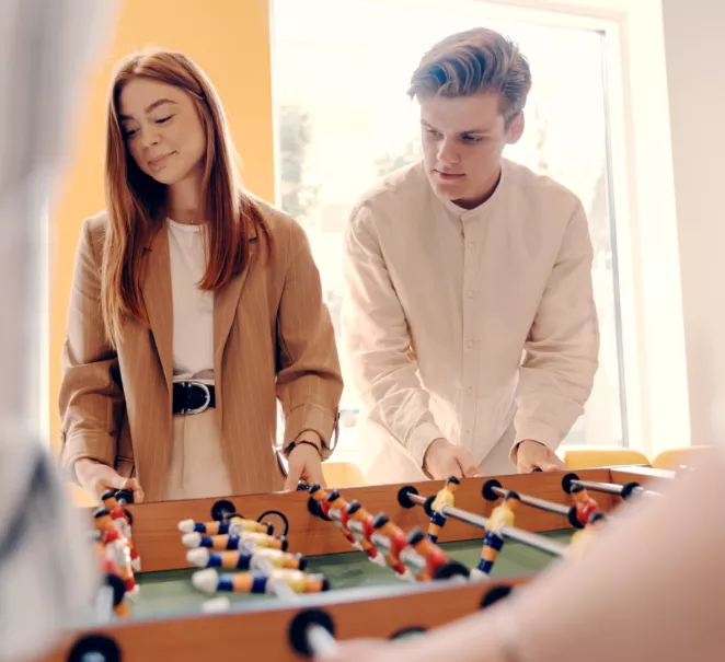 Kollegor spelar bordfotboll under en paus – en symbol för trivsel och gemenskap på arbetsplatsen